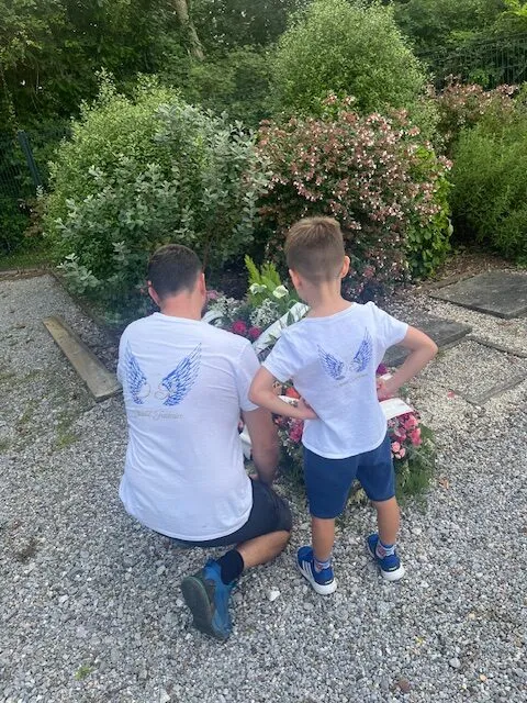 Famille avec t-shirts personnalisés se recueillant devant une tombe