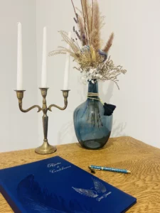 Espace hommages avec bougeoir doré, fleurs séchées et livre de condoléances