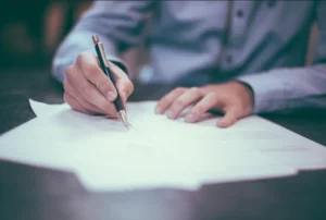 Signature de contrats et formulaires administratifs lors d'un rendez-vous.